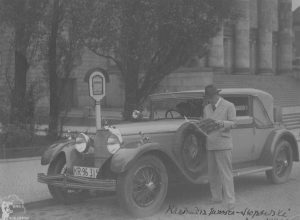 1930 r. Kazimierz Junosza-Stępowski przegląda gazetę przy swym samochodzie. Źródło: Narodowe Archiwum Cyfrowe