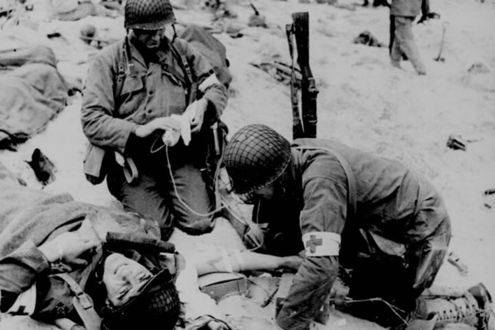 Sanitariusze podają kroplówkę rannemu w czasie lądowania w Normandii. Źródło: Projekt PhotosNormandie.